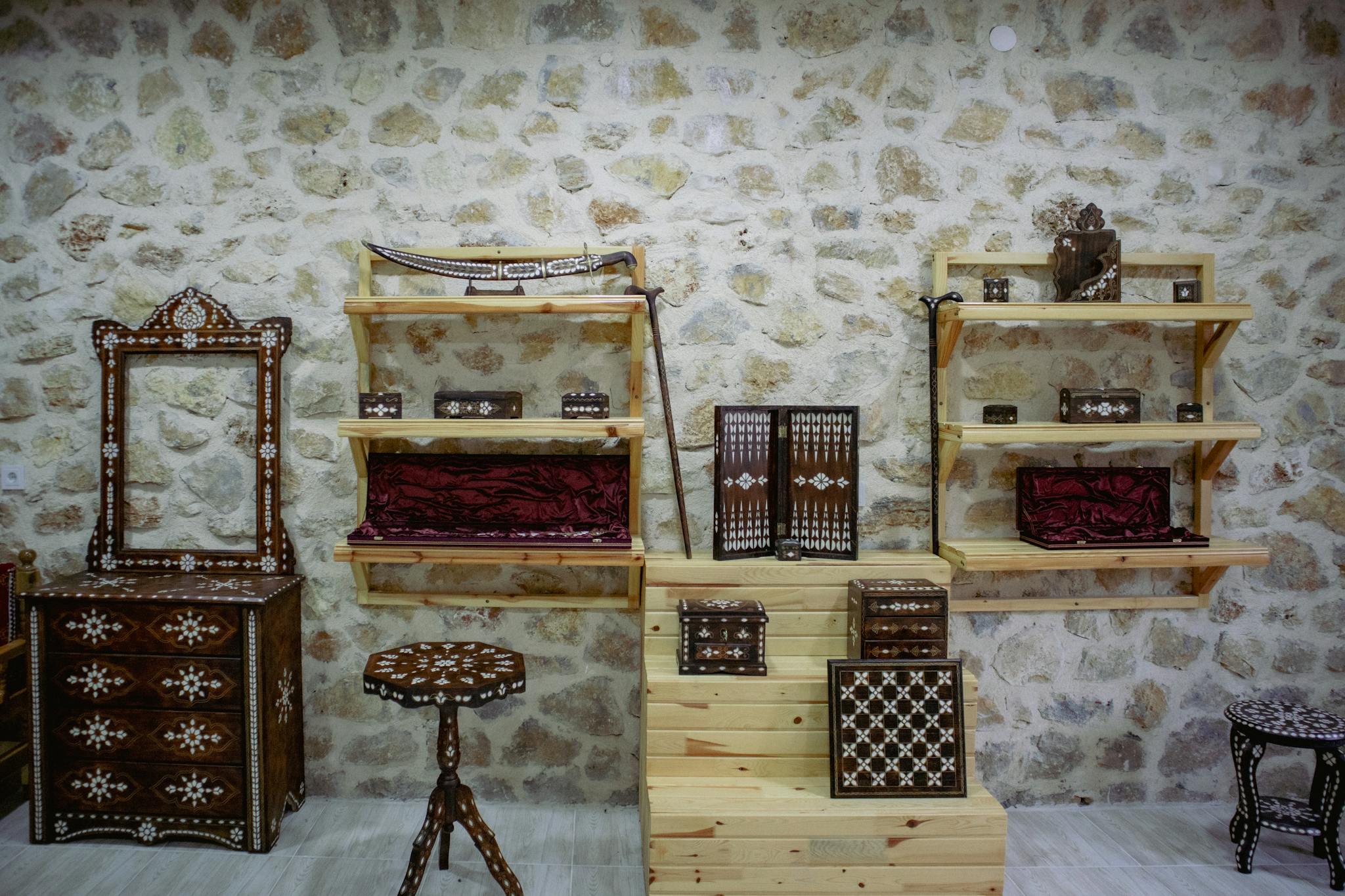 Traditional Turkish wooden furniture with intricate designs in a stone-walled room, showcasing heritage decor.